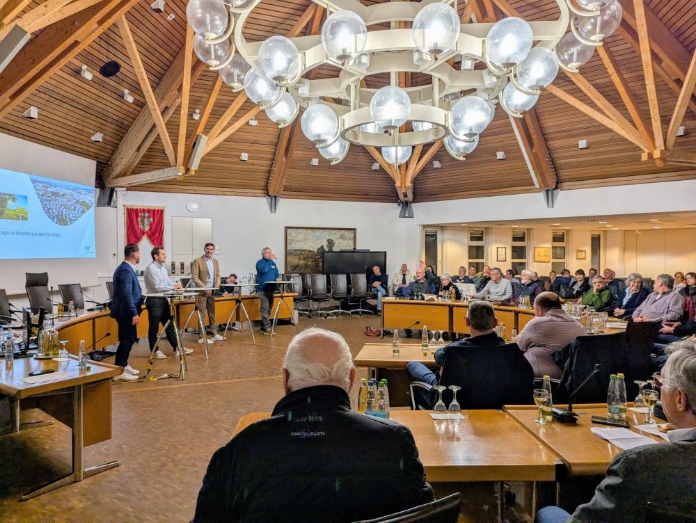 Im Sitzungssaal des Rathauses stehen die Experten zur Podiumsdiskusion zusammen