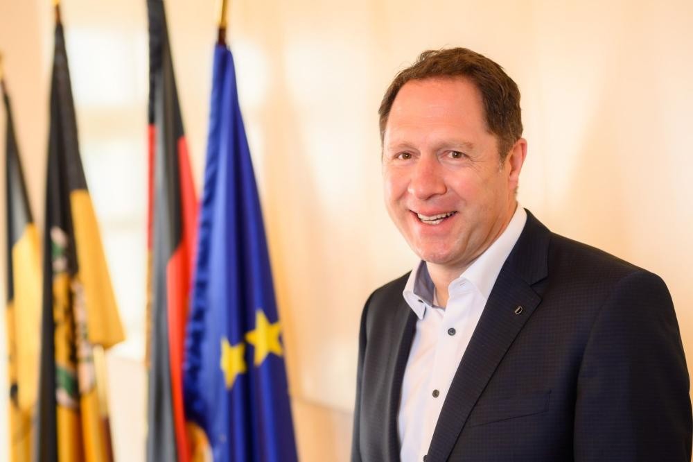 Oberbürgermeister Hartmut Holzwarth vor den Flaggen des Landes BW, Deutschlands und Europas