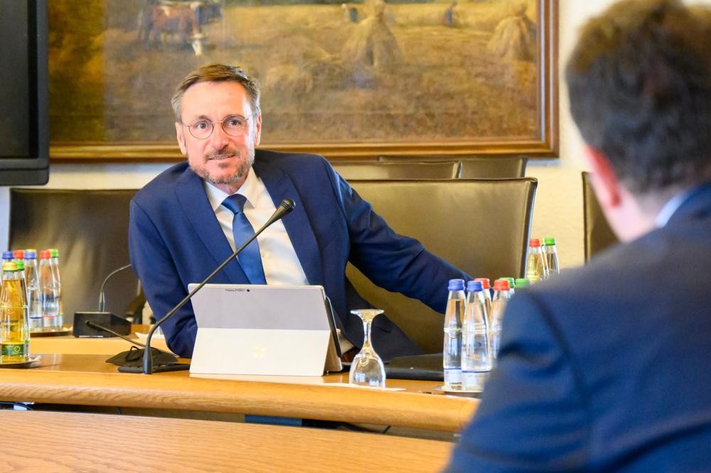 Bürgermeister Jürgen Haas lehnt sich im Sitzungssaal an das Mikrophon .