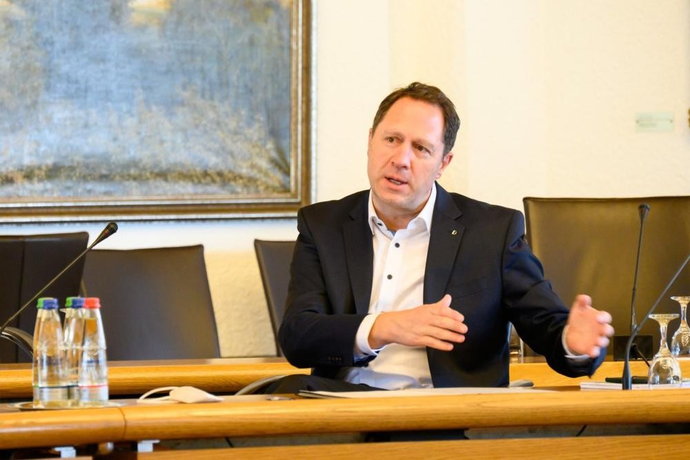 Oberbürgermeister Hartmut Holzwarth macht eine erklärende Geste. Er sitzt in großen Sitzungssaal des Winnender Rathauses