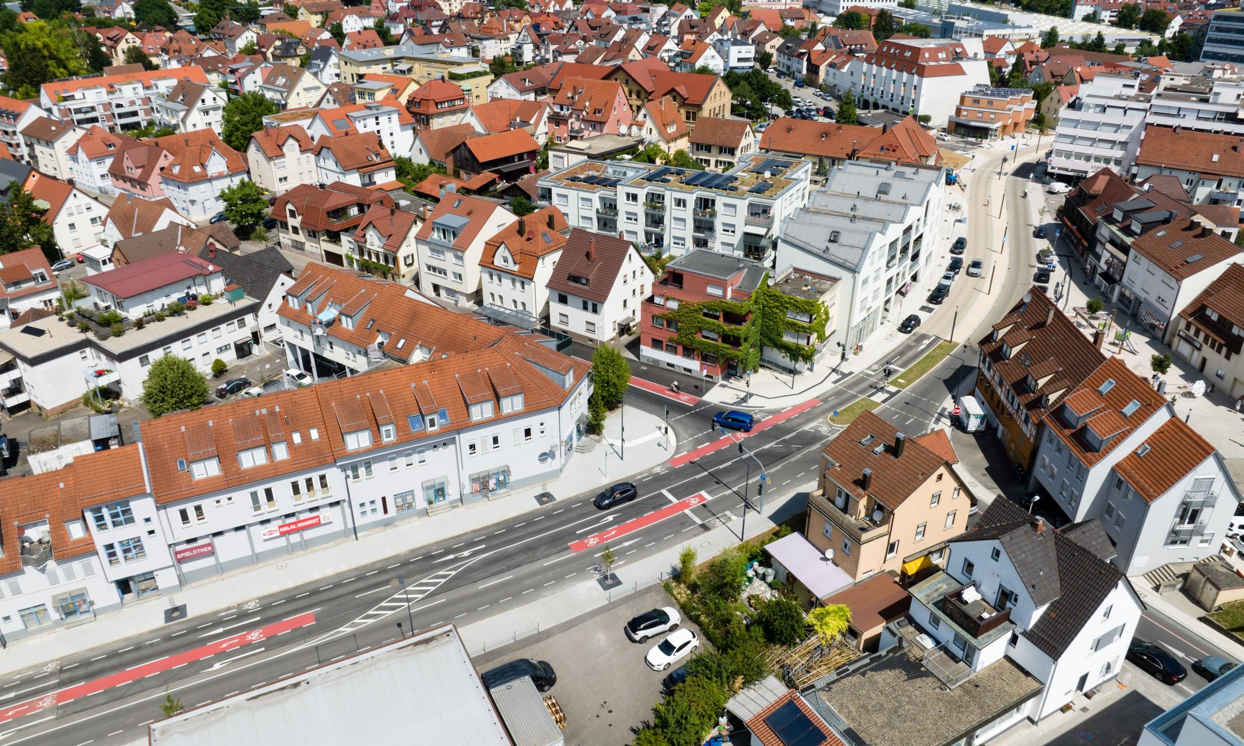 Luftansicht der neugestalteten Waiblingerstraße im Zentrum der Stadt. Auf den Fahrbahnen stechen die roten Markierungen der Fahrradstrecken hervor.