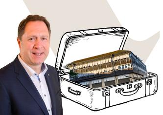 Oberbürgermeister Hartmut Holzwarth neben einer Grafik: Rathaus Winnenden in einem Koffer