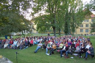 Das Publikum sitzt auf Stühlen im Winnender Schlosspark.
