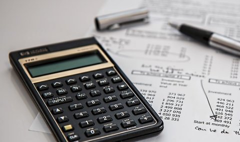 Symbolbild. Ein Taschenrechner liegt ein einem Papier. Auf diesem stehen Kalkulationen.