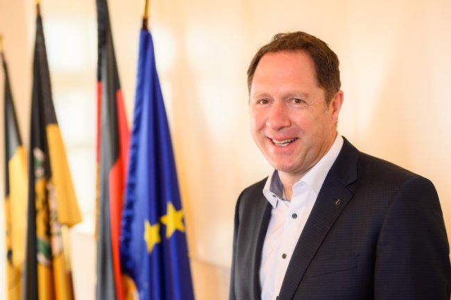 Oberbürgermeister Hartmut Holzwarth vor den Fahnen der EU, des Landes BW, Deutschlands und Winnendens