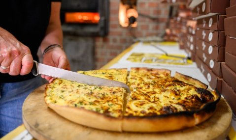 Ein Salzkuchen wird auf einem Holzbrett in Stücke geschnitten