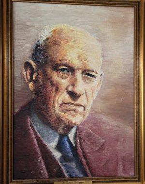 Das Ehrenbürgergemälde zeigt Dr. Dr. h.c. Robert Boehringer in einem dunkelroten Anzug mit blauer Krawatte ernst zum Betrachter blickend.