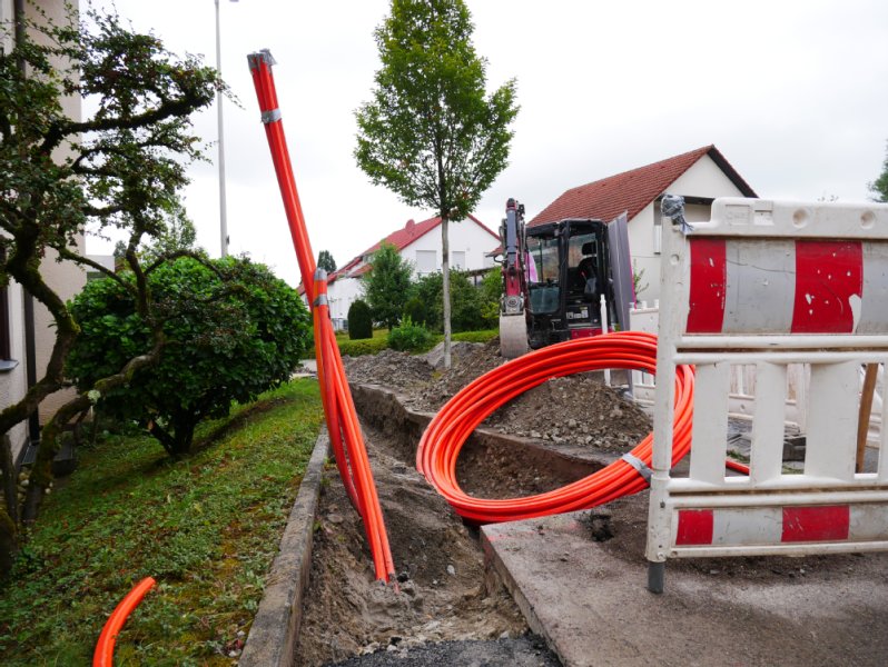 Ein Glasfaserkabel schaut aus dem Boden an einer Baustelle zur Verlegung der Leitung