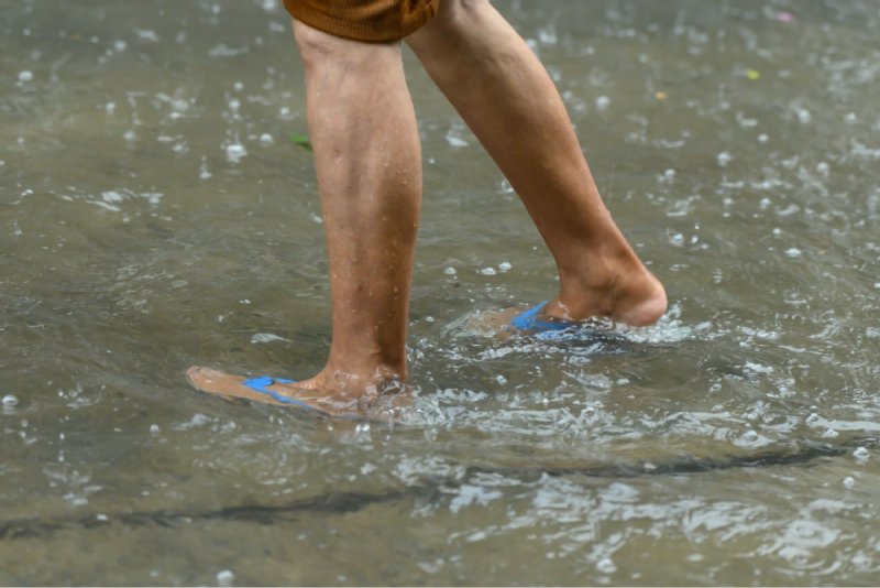Symbolfoto: Eine Person steht bis zu den Knöcheln im Wasser.