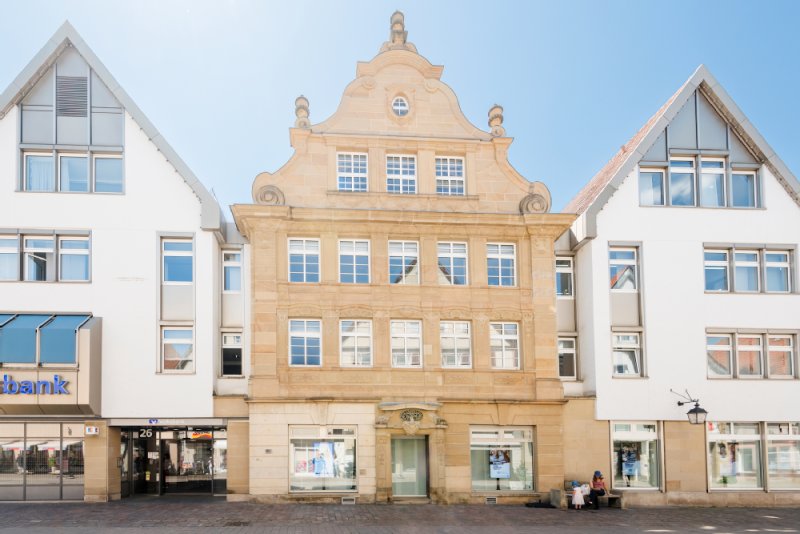 Das hellbeige Haus mit dem verschnörkelten Giebel und den zahlreichen Fenstern.