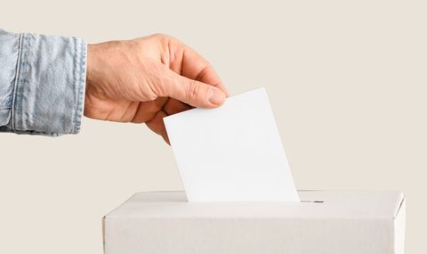 Symbolbild: Stimmzettel wird in eine Wahlurne geworfen