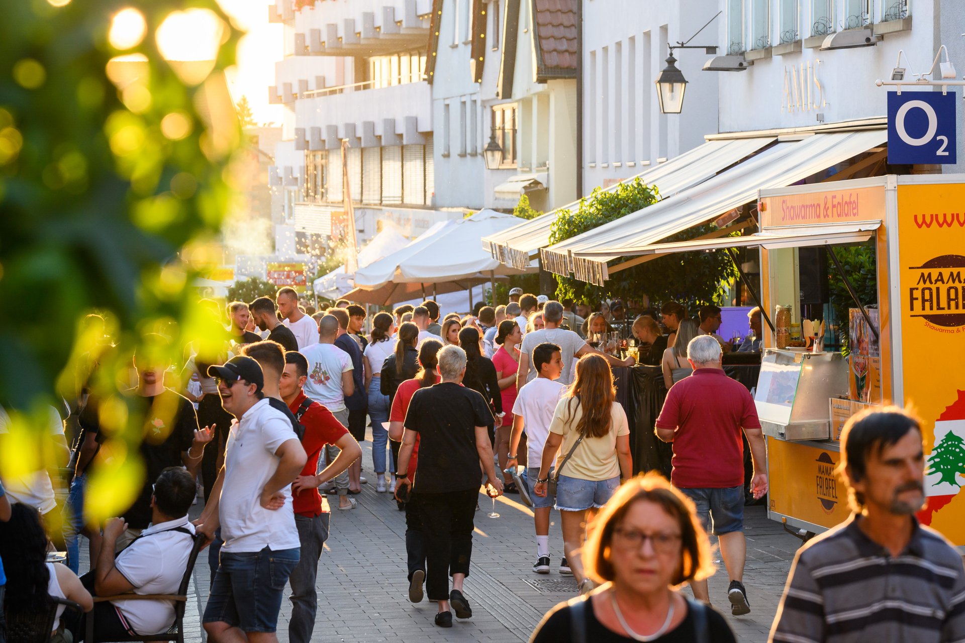 Auf der Marktstraße stehen mehrere Stände. Dazwischen laufen Besucherinnen und Besucher.