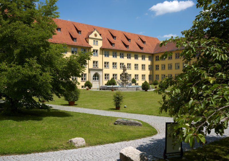 Hinter dem Schloss Winnenden befindet sich der Schlossgarten mit einem Brunnen und zahlreichen Bäumen.