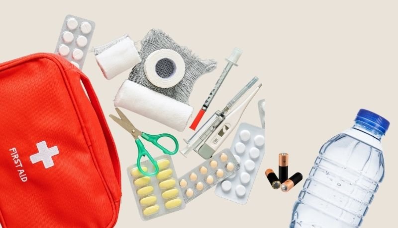 Symbolfoto: Ein Erstehilfekoffer liegt ausgebreitet neben einer Wasserflasche und Batterien-