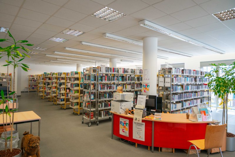 Die Stadtbücherei Winnenden mit der Bedientheke und mehreren Gängen voller Bücher