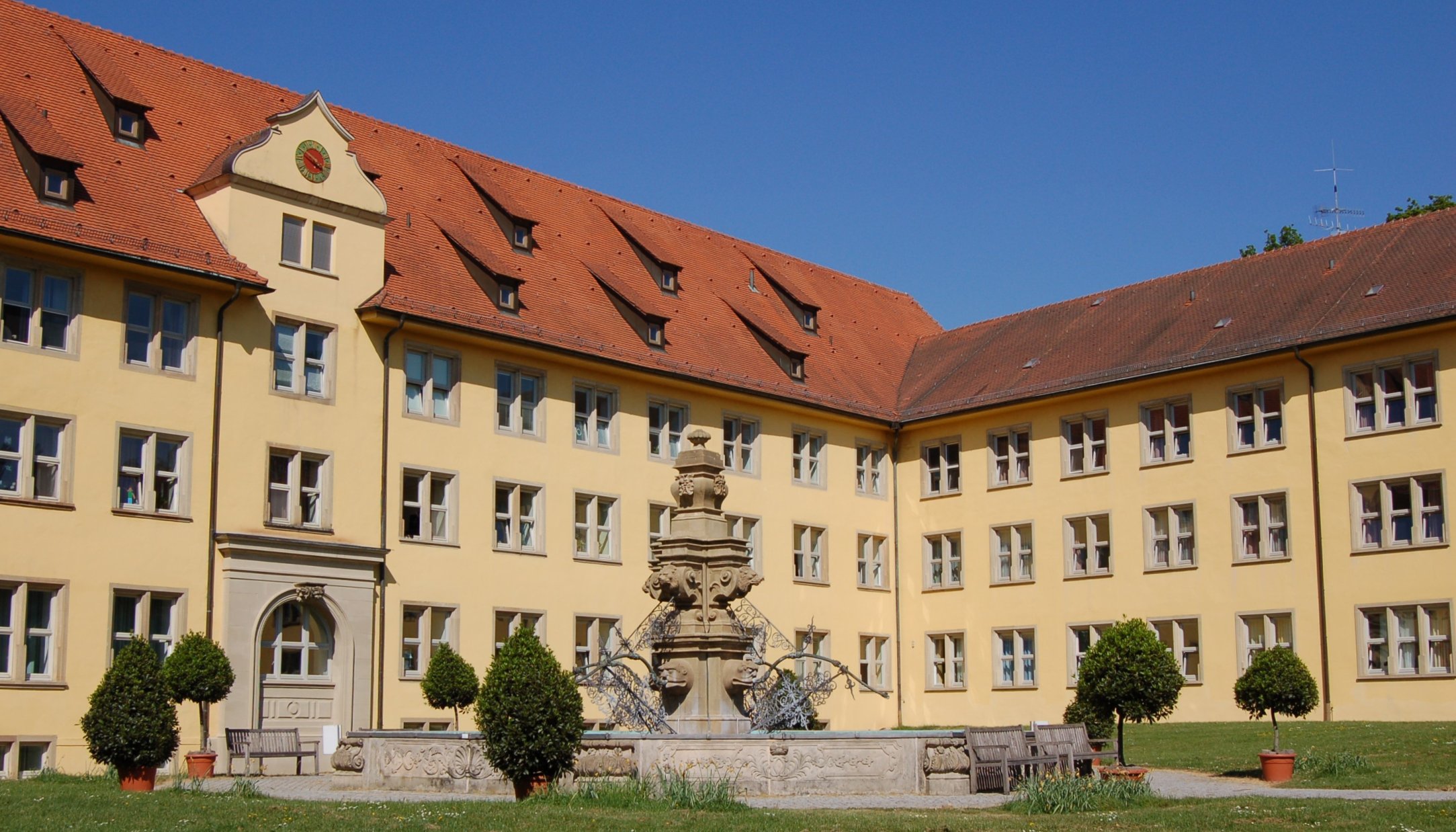 Der Garten des Schloss Winnenden mit Blick auf das Schloss und den Brunnen.