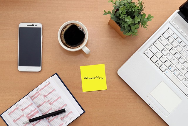 Arbeitsutensilien wie Kalender, Smarthone und Laptop auf einem Küchentisch