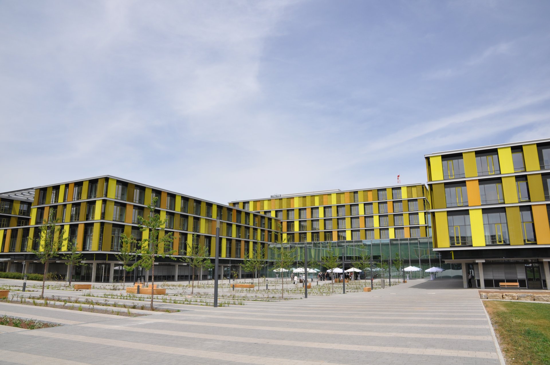 Dere Eingangsbereich des Rems-Murr-Klinkums Winnenden. Auf dem hof sind Bäume und Sitzbänke vor dem Klinikum mit seiner grünen Fassade zu sehen. 