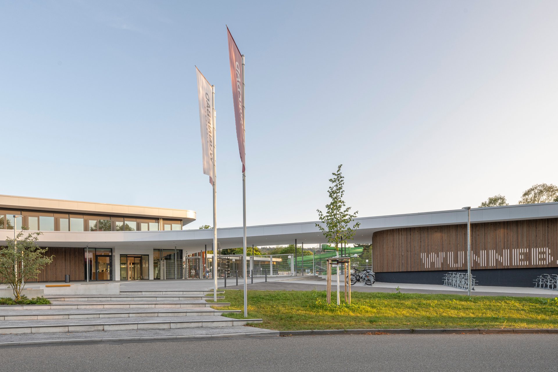 Der Eingang des Wunnebads mit den Drehtüren und der Holzfassade, auf welcher der Schriftzug "Wunnebad" zu lesen ist.