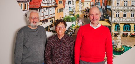Gruppenfoto des Vorstands des Seniorenrats vor einer beigen Wand mit einem Bild, welches die Marktstraße in Winnenden zeigt.