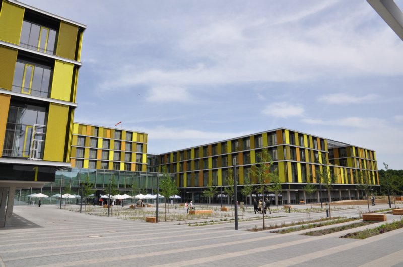 Vor dem Eingang der Rems-Murr-Klinik Winnenden laufen Personen zwischen den Bäumen und Sitzgelegenheiten