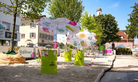 Sandstrand, Sonnenschirme und Klettergerüst.