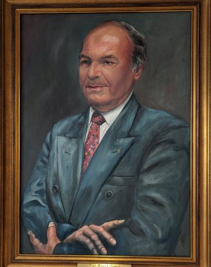 Das Ehrenbürgergemälde zeigt Karl-Heinrich Lebherz im blauen Anzug mit roter Krawatte nach links schauend. 