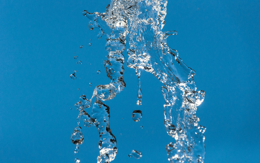 Nahaufnahme von in der Luft schwebenden Wassertropfen vor blauem Himmel