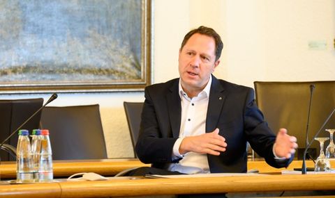 Oberbürgermeister Hartmut Holzwarth sitzt im Sitzungssaal des Winnender Rathauses und befindet sich in einem Gespräch