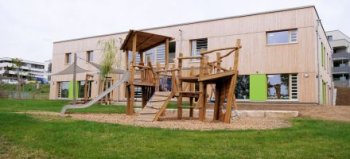 Der Kindergarten Adelsbach mit einem großen Garten und zahlreichen Spielgeräten.