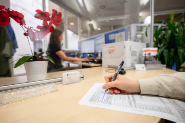 Bürgerin füllt einen Antrag in der Bürgerservicestelle aus. 